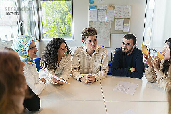 Schüler diskutieren am Tisch im Klassenzimmer