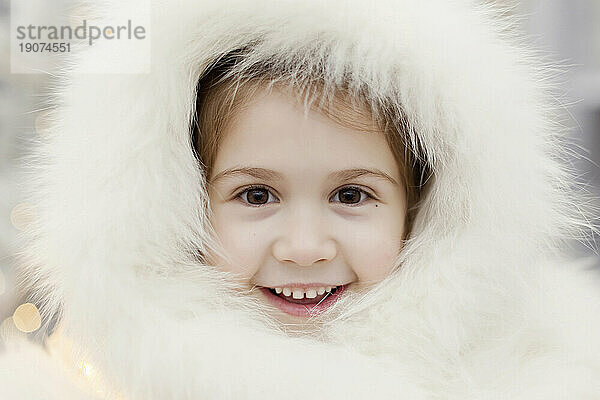 Lächelndes Mädchen mit weißer Pelzmütze