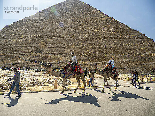 Tourist auf einem Kamelritt vor der Großen Pyramide von Gizeh  dem ältesten der sieben Weltwunder  UNESCO-Weltkulturerbe  in der Nähe von Kairo  Ägypten  Nordafrika  Afrika