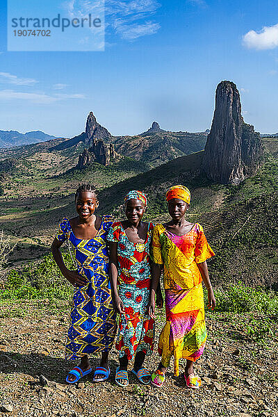 Three Kapsiki tribal girls in front of the lunar landscape of Rhumsiki   Rhumsiki  Mandara mountains  Far North province  Cameroon  Africa