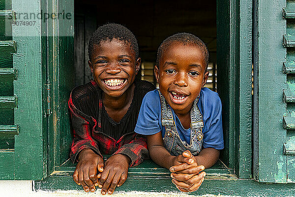 Young school kids looking out from a window  Ciudad de la Paz  Rio Muni  Equatorial Guinea  Africa