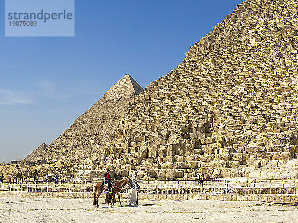 Touristen auf Kamelritt vor der Großen Pyramide von Gizeh  dem ältesten der sieben Weltwunder  UNESCO-Weltkulturerbe  Gizeh  in der Nähe von Kairo  Ägypten  Nordafrika  Afrika