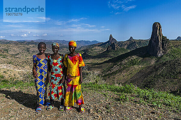 Three Kapsiki tribal girls in front of the lunar landscape  Rhumsiki  Mandara mountains  Far North province  Cameroon  Africa