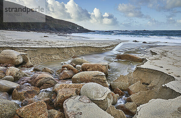 Ein Bach durchschneidet Sand und Felsen auf seinem letzten Weg zum Meer  Portheras Cove  einer abgelegenen Bucht an der Atlantikküste  in der Nähe von Pendeen  im äußersten Westen von Cornwall  England  Vereinigtes Königreich  Europa
