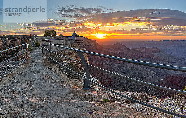Ein einsamer Wanderer am Angels Window Overlook am Grand Canyon North Rim Arizona mit Blick auf den Sonnenaufgang.