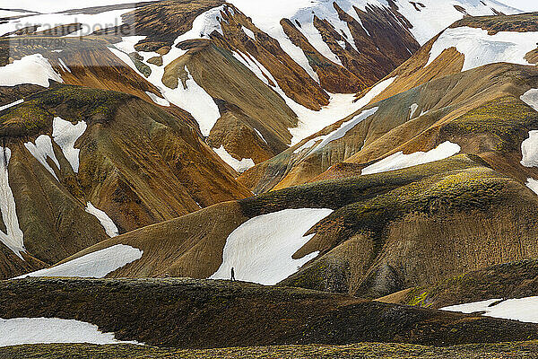 Eine Person genießt die wunderschöne Landschaft im Berg Landmannalaugar an einem Sommertag  Island  Polarregionen