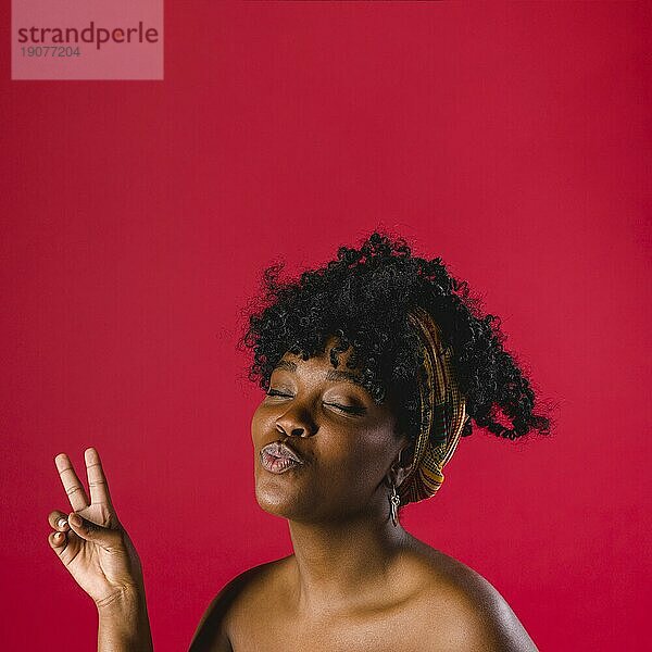 Attraktive nackte afrikanische junge Frau mit Friedenszeichen Studio mit hellem Hintergrund