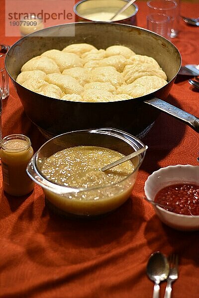 Dampfnudeln in rustikaler alter Dampfnudelpfanne  mit Apfelmus und Johannisbeeren  typisch traditionell bayerische Küche  Deutschland  Europa