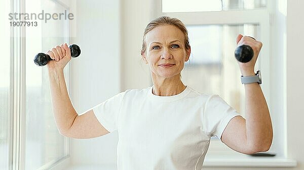 Medium shot Frau hält Hanteln