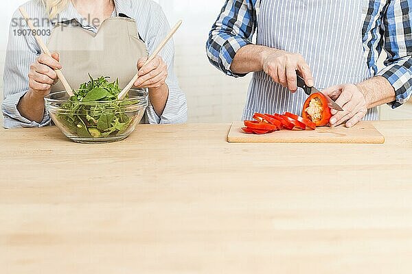 Close up Frau bereitet Salat ihr Mann Schneiden Paprika Holztisch