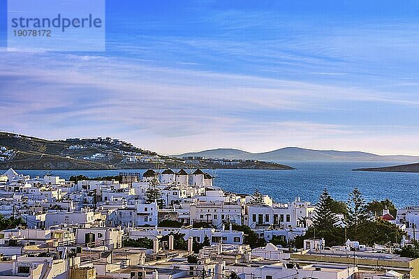 Berühmte Touristenattraktion von Mykonos  Kykladen  Griechenland. Sonnenuntergang über traditionellen weiß getünchten Windmühlen am Wasser und Chora Stadt. Sommerlicher Sonnenuntergang  blauer Himmel  schöne Wolken. Reiseziel  ikonische Ansicht