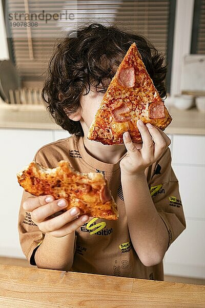 Kind ißt Pizza zu Hause
