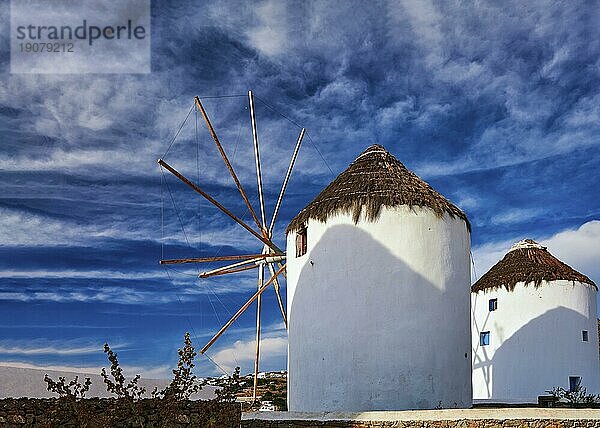 Berühmte Touristenattraktion von Mykonos  Kykladen  Griechenland. Zwei traditionelle  weiß getünchte Windmühlen am Wasser und in der Stadt Chora. Sommer  blauer Himmel  schöne Wolken. Reiseziel  ikonische Ansicht. Rückansicht