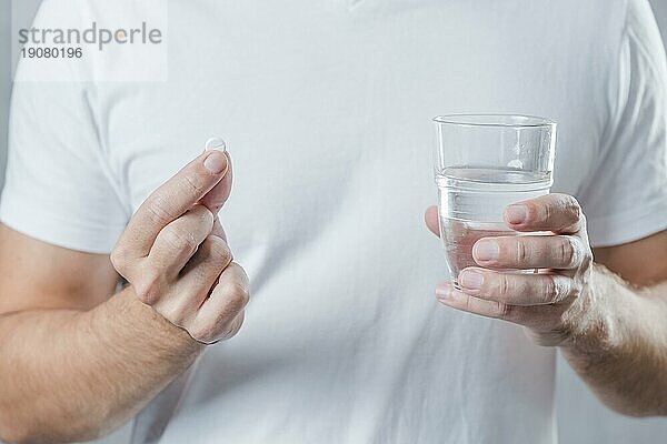 Close up Mann s Hand hält weiße Pille Glas Wasser Hand