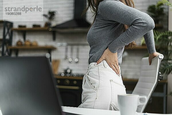 Seitenansicht Frau mit Rückenschmerzen bei der Arbeit von zu Hause aus