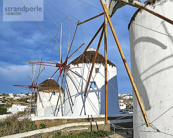 Berühmte Touristenattraktion von Mykonos  Kykladen  Griechenland. Drei traditionelle  weiß getünchte Windmühlen am Wasser und in der Stadt Chora. Sommer  blauer Himmel  schöne Wolken. Reiseziel  ikonische Ansicht. Diagonale Zusammensetzung