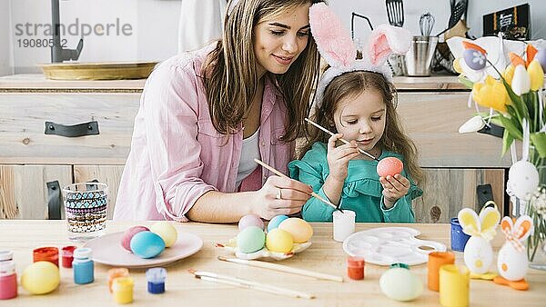 Kleines Mädchen Mutter Malerei Eier Ostern