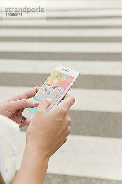 Eine Person hält ein Mobiltelefon mit einem Bildschirm für Benachrichtigungen über soziale Medien in der Hand