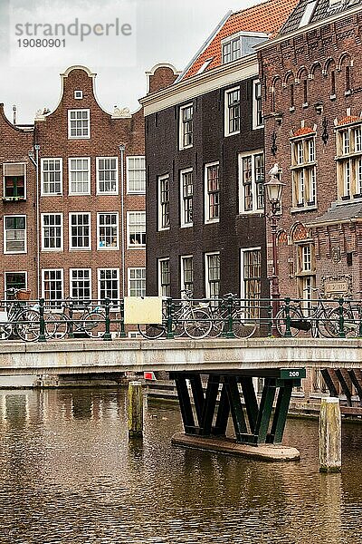 Traditionelle  historische Häuser und Brücke über die Gracht in der Altstadt von Amsterdam  Nordholland  die Niederlande