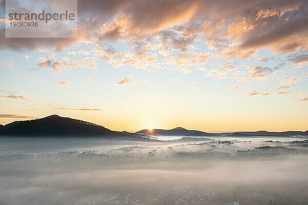 Mystischer Sonnenaufgang am Wachtfelsen. Faszinierende Landschaftsaufnahme zwischen Nebel und Wolken bei Wernersberg  Pfälzerwald  Deutschland  Europa