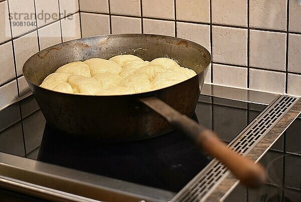 Zubereitung von Dampfnudeln in rustikaler alter Dampfnudelpfanne  typisch traditionell bayerische Küche  Deutschland  Europa