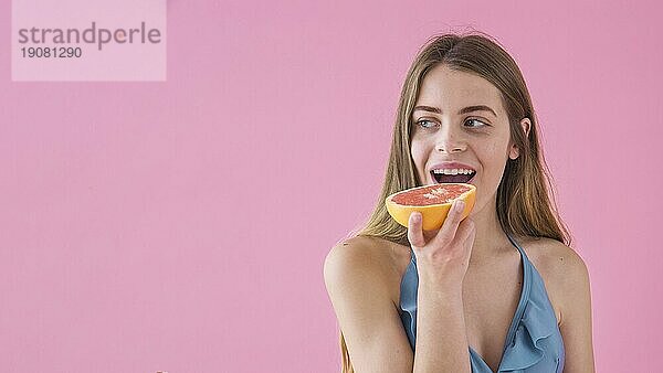 Mädchen im Bikini ißt Grapefruit
