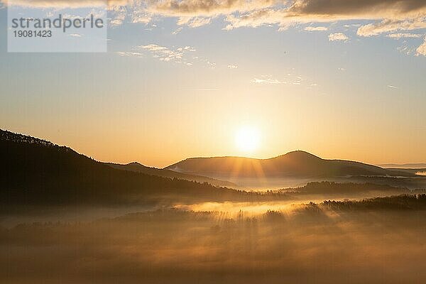 Mystischer Sonnenaufgang am Wachtfelsen. Faszinierende Landschaftsaufnahme zwischen Nebel und Wolken bei Wernersberg  Pfälzerwald  Deutschland  Europa