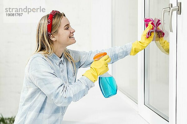 Seitenansicht Frau putzt Fenster