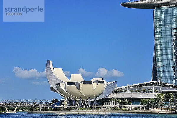 Singapur  25. Februar 2020. Berühmtes Touristenziel  ArtScience Museum by Marina Bay Sands  Shoppes Einkaufszentrum und Helixbrücke in der Marina Bay  an einem sonnigen Tag. Sehenswerte Wahrzeichen des Stadtstaates  klarer blauer Himmel  azurblaues Wasser. Ikonische futuristische Architektur und Symbole  Asien