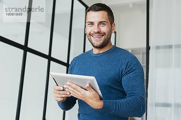 Lächelnder Mann mit Tablette aus niedrigem Winkel