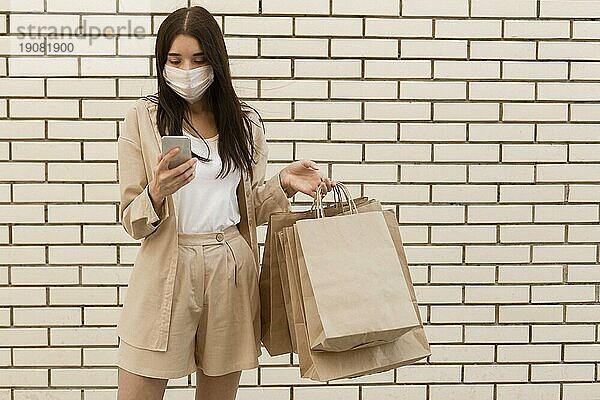 Frau mit Einkaufstüten und Maske  Vorderansicht