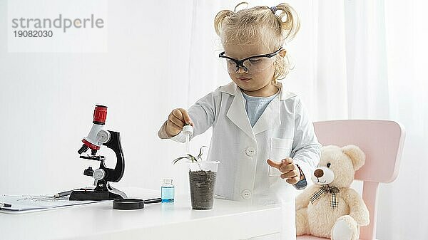 Vorderansicht niedliches Kleinkind  das mit einem Pflanzenmikroskop etwas über Wissenschaft lernt