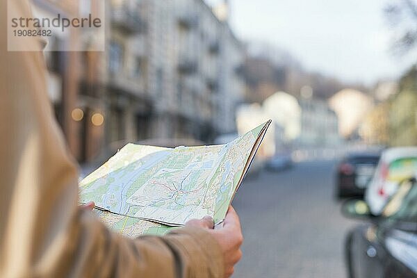 Close up männlichen Reisenden hält Karte Hand stehend Stadt Straße