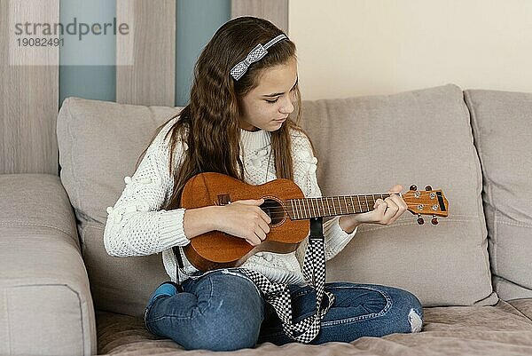 Mädchen zu Hause spielt Gitarre