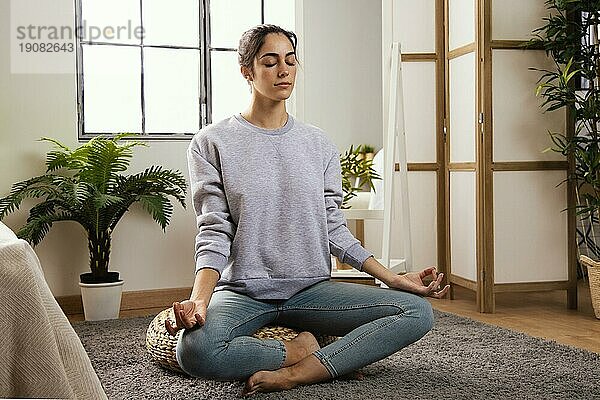 Vorderansicht junge Frau meditiert zu Hause
