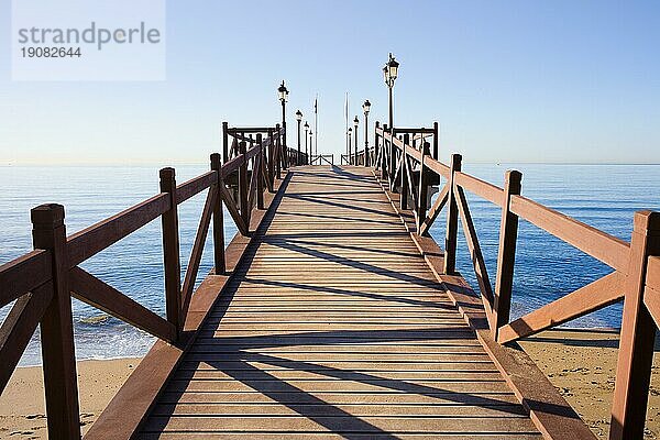 Holzpier in gutem Zustand mit Schranken und Laternen an einem ruhigen Mittelmeer in Marbella  Costa del Sol  Andalusien  Spanien  Europa