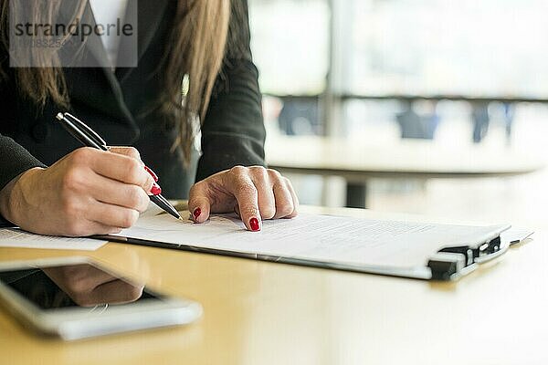 Brünette Geschäftsfrau schreibt Dokument