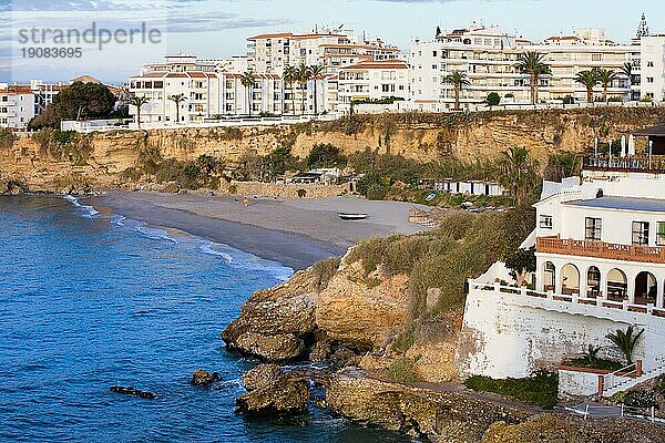 Kleiner  ruhiger Strand  umgeben von Klippen und Apartmenthäusern im malerischen Ferienort Nerja an der Costa del Sol  Andalusien  Südspanien