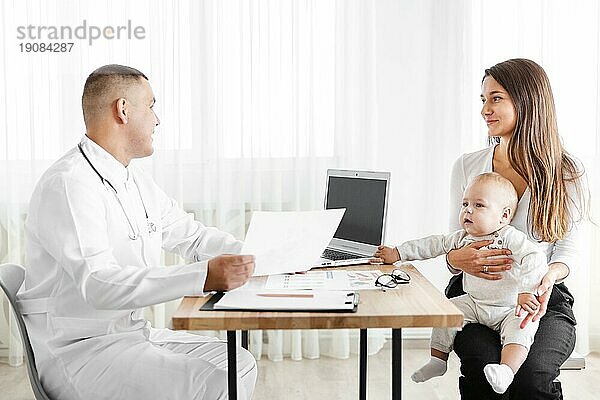 Seitenansicht Arzt im Gespräch mit Mutter und Kind