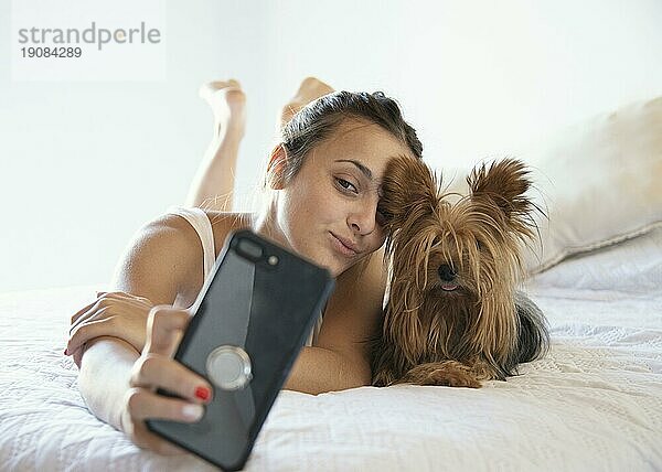 Junge Frau mit Hund nimmt Selfie