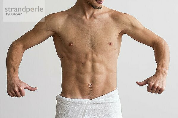 Vorderansicht eines Mannes ohne Hemd  der seine Bauchmuskeln zeigt