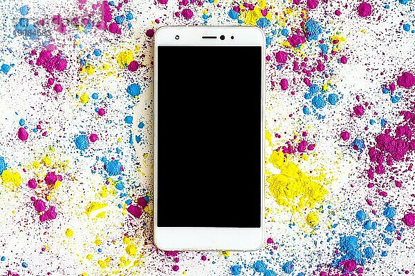 Holi Farbpulver um Smartphone mit schwarzem Bildschirm