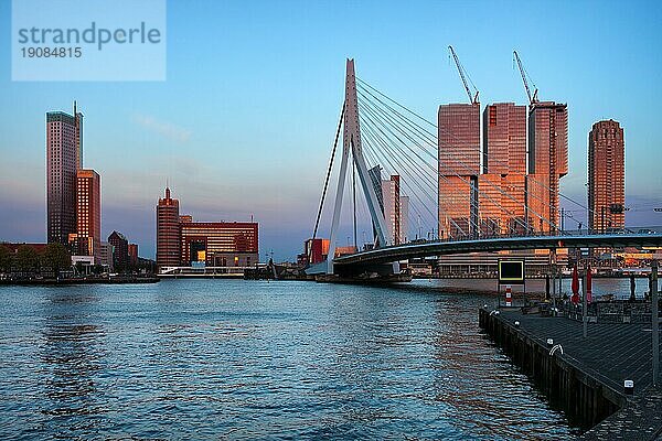 Stadtzentrum von Rotterdam bei Sonnenuntergang in Holland  Niederlande  Skyline der Innenstadt  Wolkenkratzer und Erasmusbrücke (Erasmusbrug) auf der Nieuwe Maas  Europa