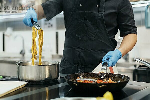 Frontansicht Koch mit Handschuhen Kochen Pasta Küche