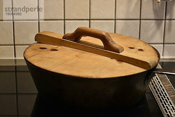 Zubereitung von Dampfnudeln in rustikaler alter Dampfnudelpfanne mit Holzdeckel  typisch traditionell bayerische Küche  Deutschland  Europa