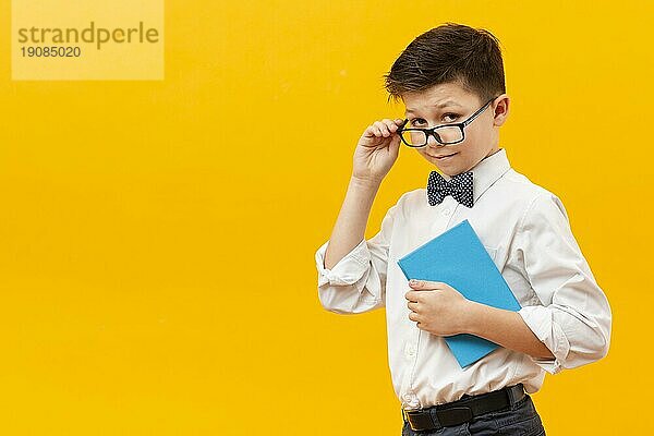 Junge mit Brille hält Buch