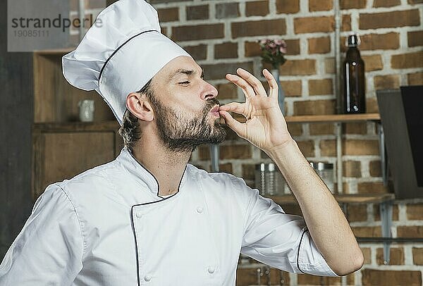 Professioneller männlicher Chefkoch zeigt Zeichen köstlich