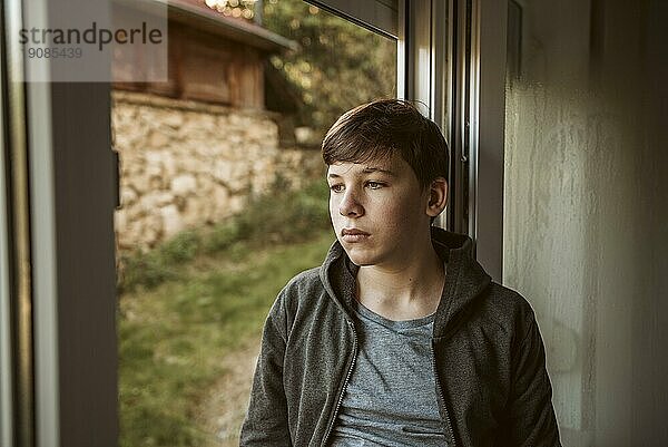 Vorderansicht trauriger Junge schaut nach draußen