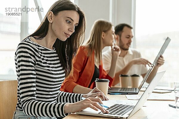 Junge Geschäftsleute arbeiten am Laptop