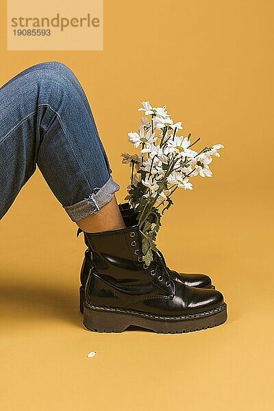 Sitzende weibliche Beine Stiefel mit Blumen innen